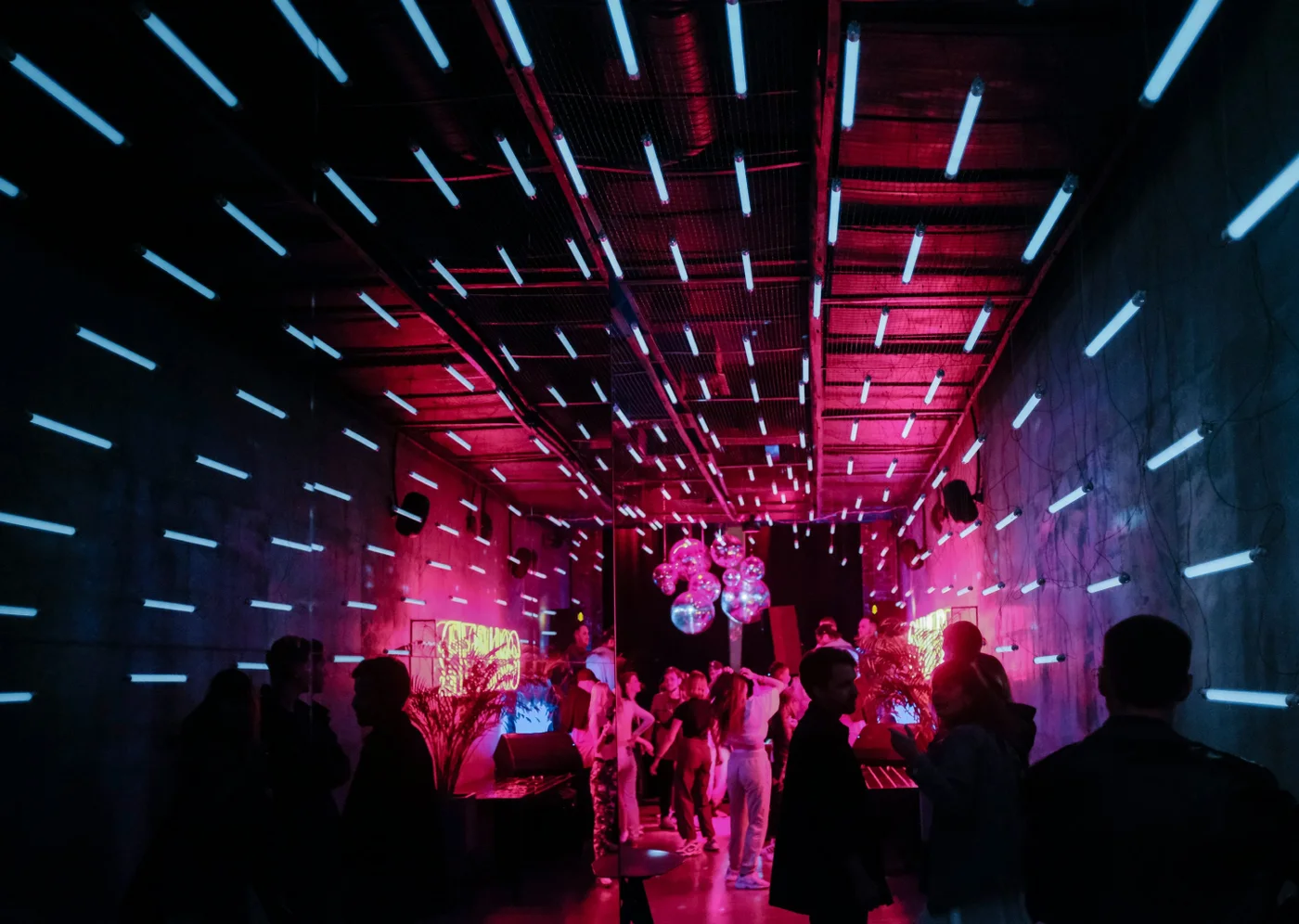 An immersive evening gathering beneath a canopy of pink and blue lights